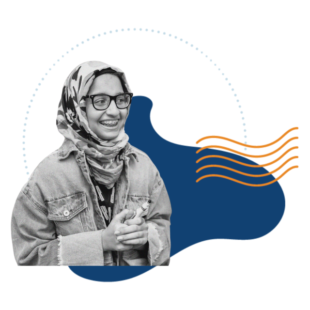 A greyscale photo of a girl in a patterned hijab wearing glasses and a denim jacket smiling over a dark blue graphical element.