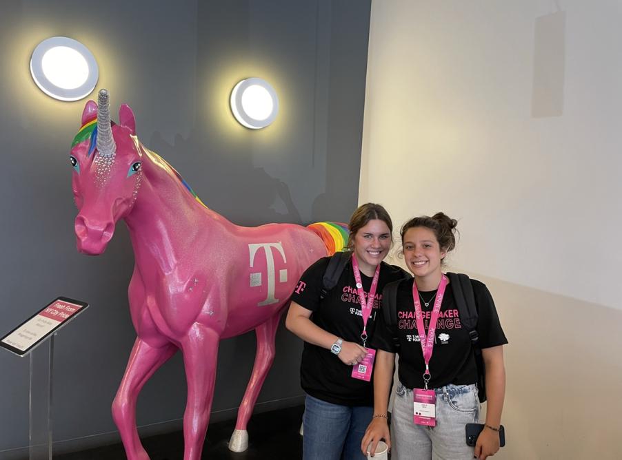 Jacqueline and Amelie at the T-Mobile Changemaker Challenge event. They are standing next to a horse statue painted pink.
