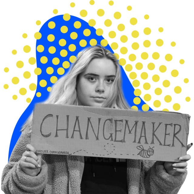 A woman holding a "Changemaker" sign